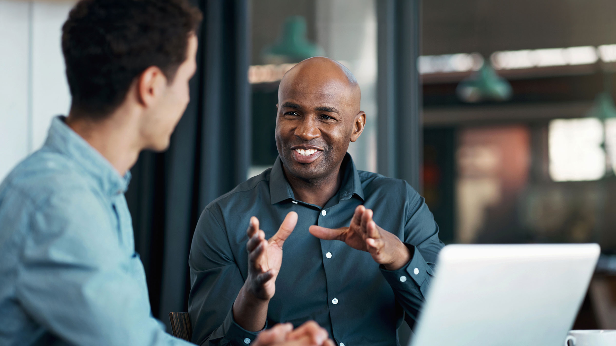 Smiling senior executive talking to young colleague