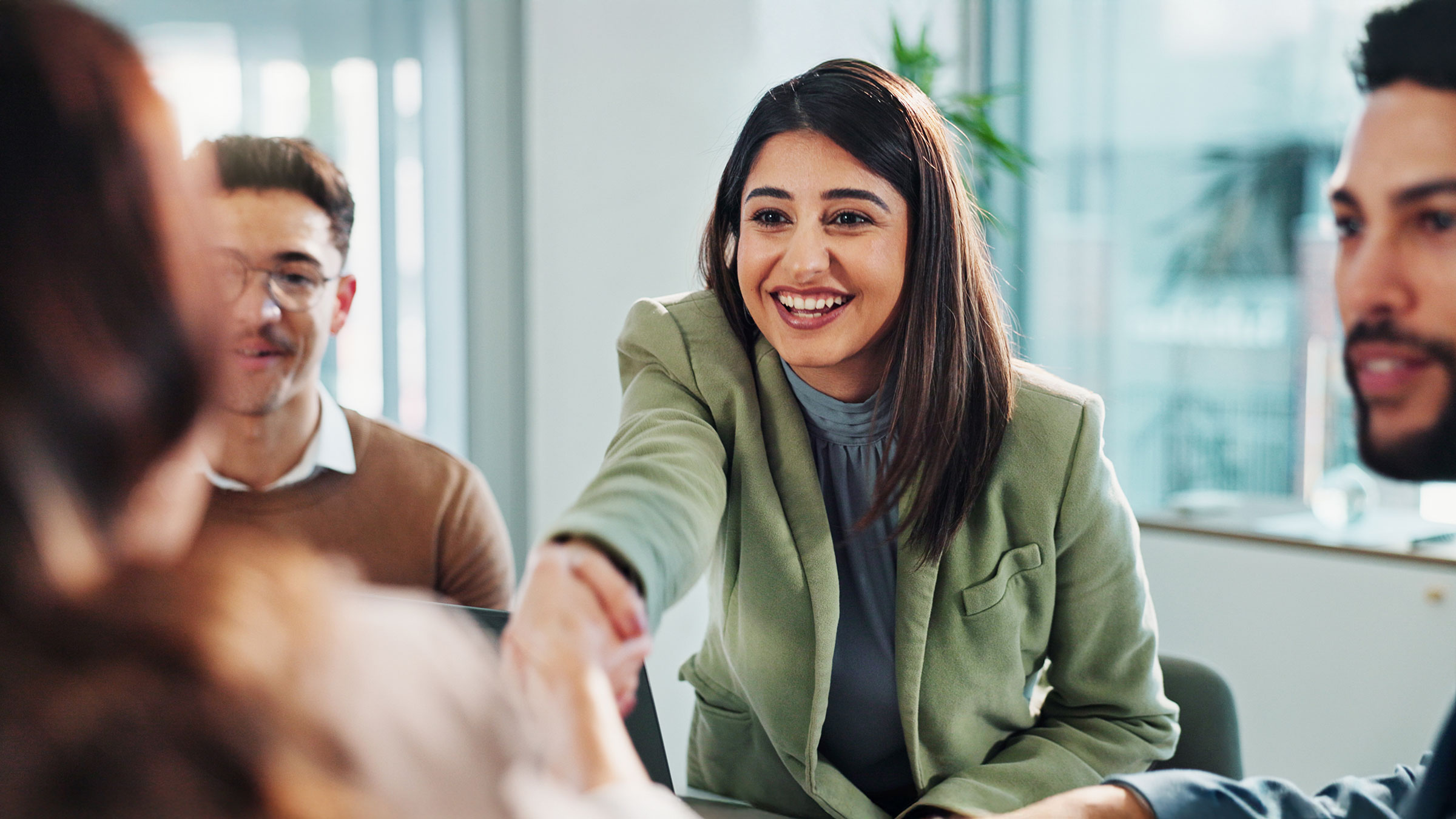 Woman shaking hand in agreement in a meeting
