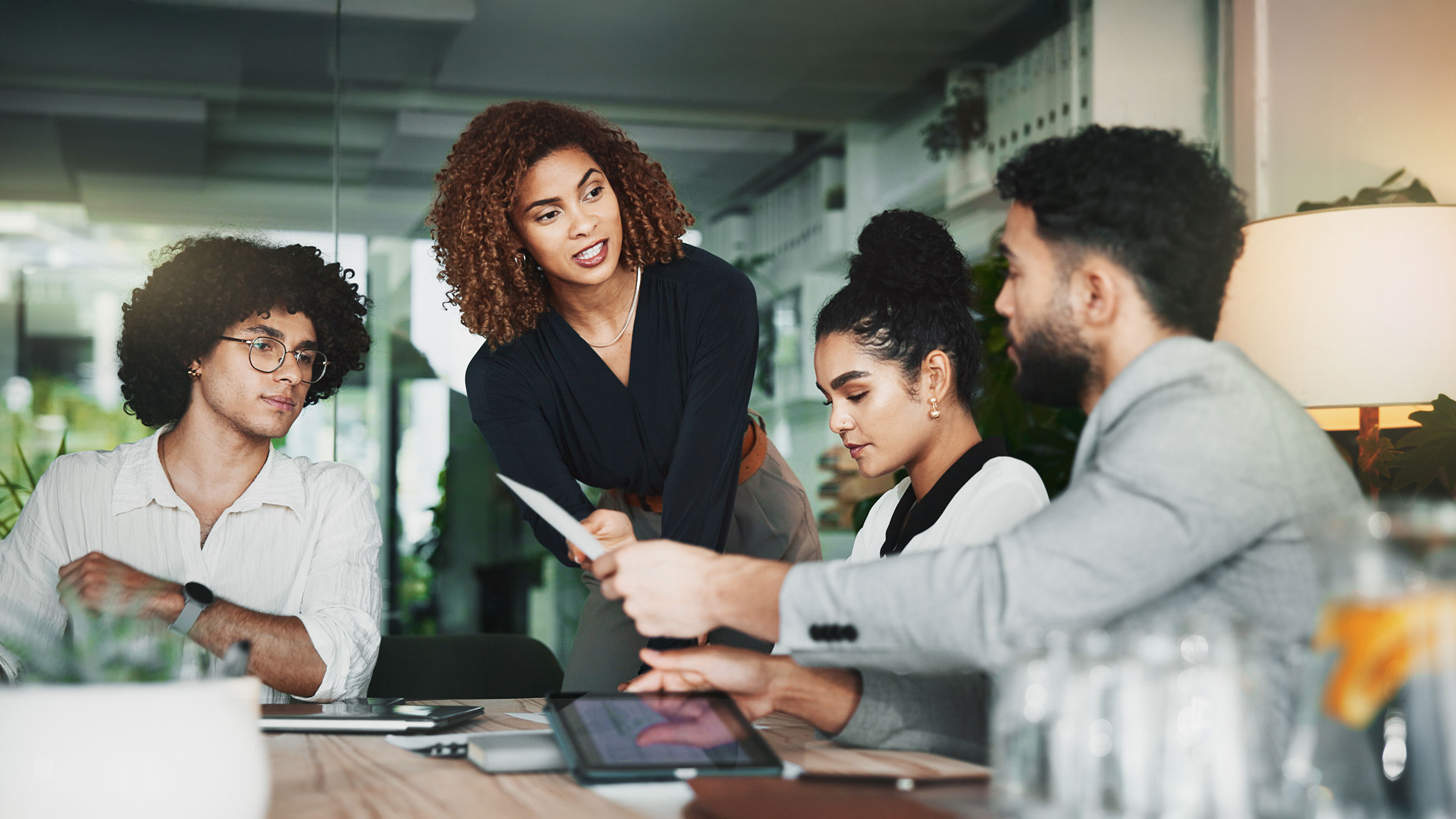 Employee handing document to boss in team meeting