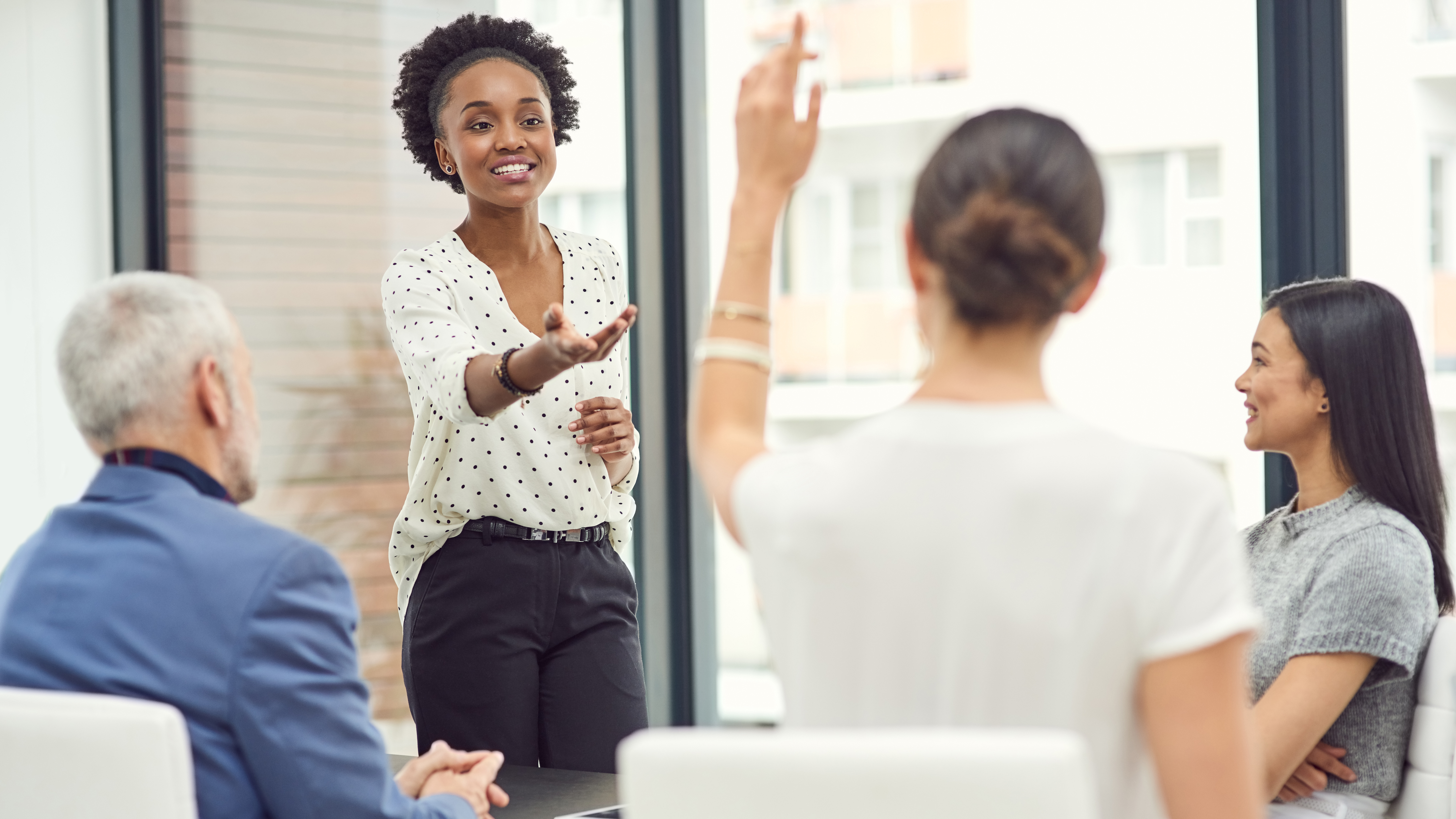 A woman raising her hand in a meeting