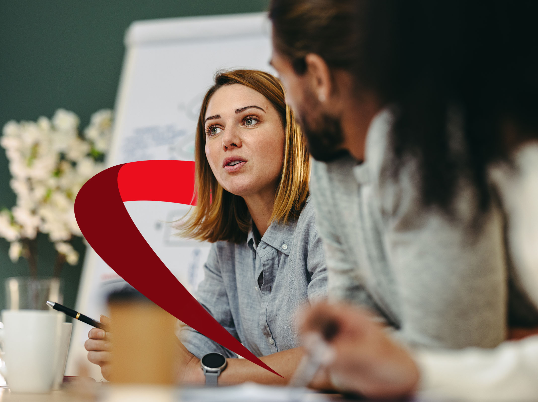 Professional woman earnestly discusses ideas with colleague in meeting room, illustrating adaptive leadership collaboration.