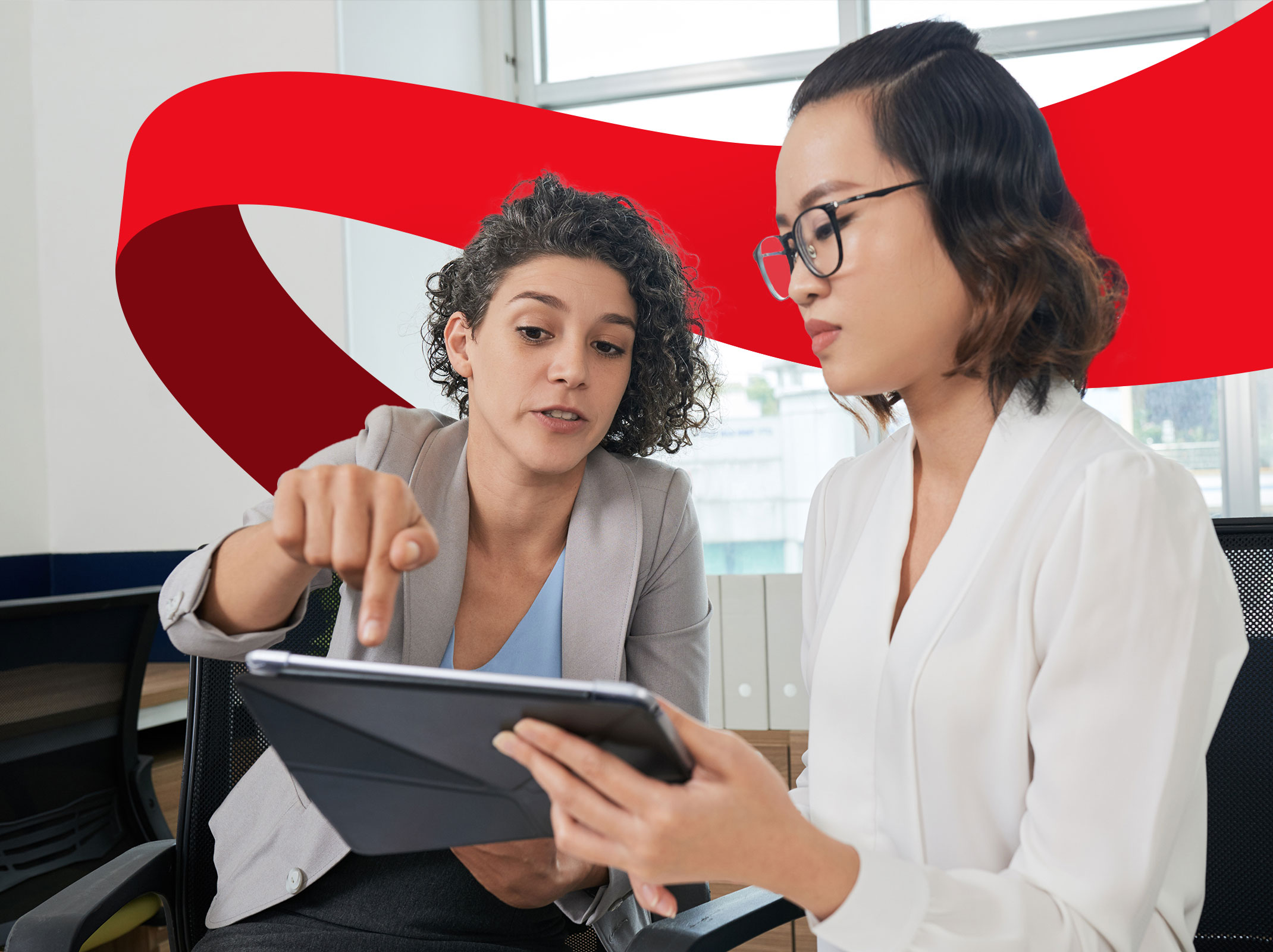 Two business professionals reviewing something on a tablet in a business setting. One person is gesturing dramatically at the tablet.