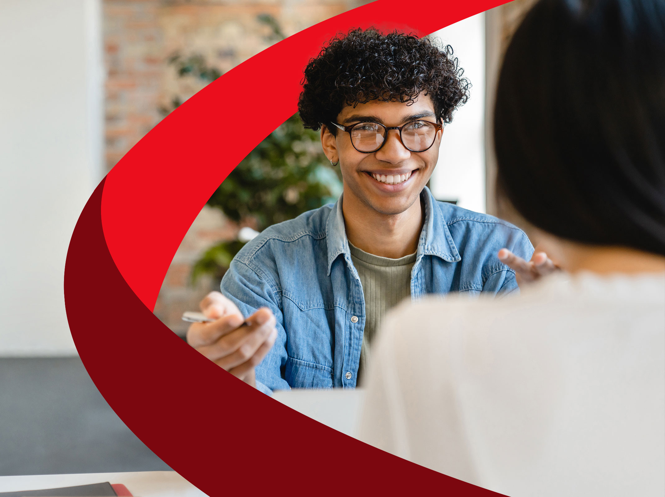 A business professional having a pleasant conversation with another person in an office setting.  They appear to have a good interpersonal relationship.