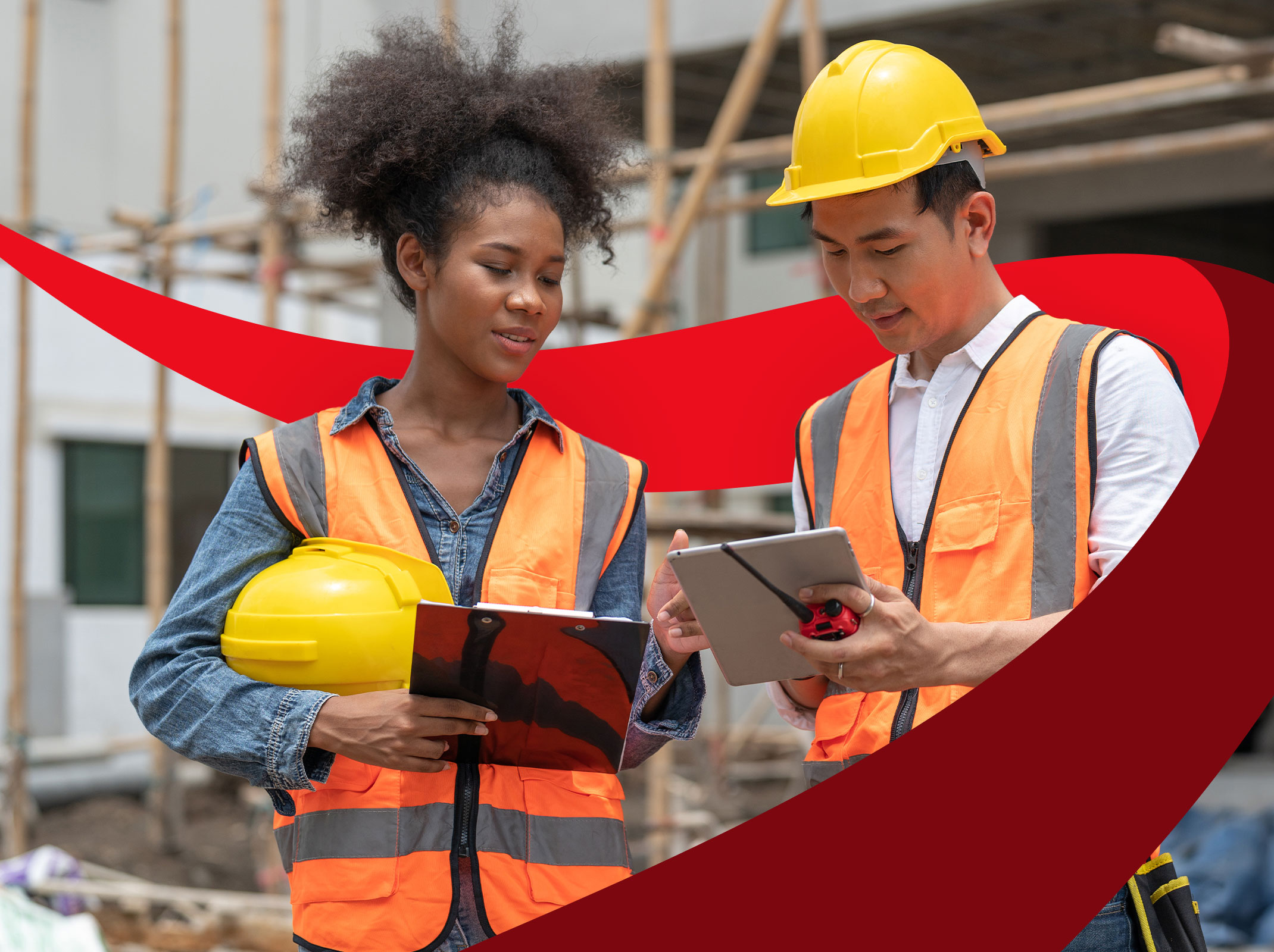 Two people on a construction site wearing safety gear
