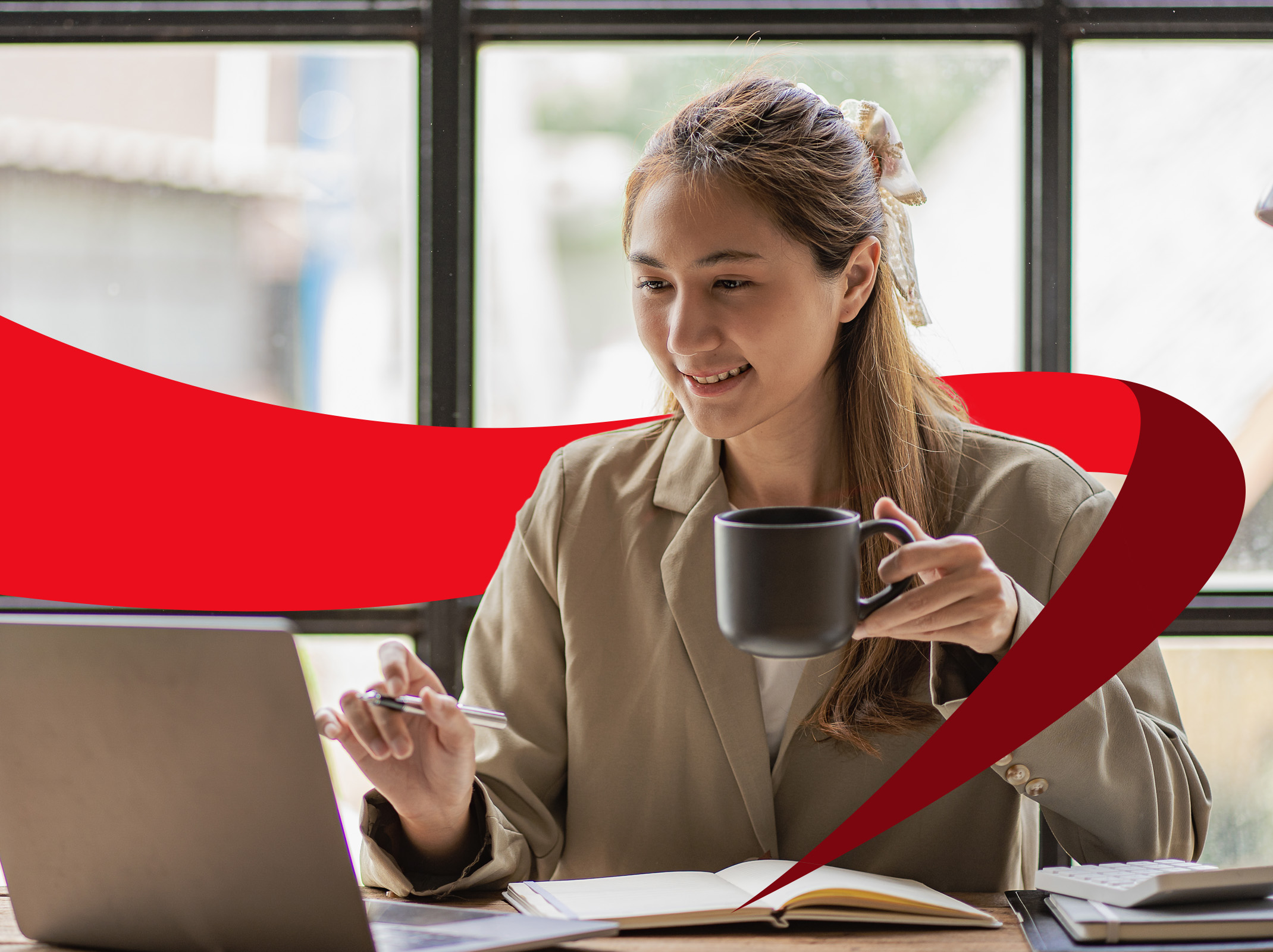 Professional women with coffee at her laptop enjoying her day being productive at work.