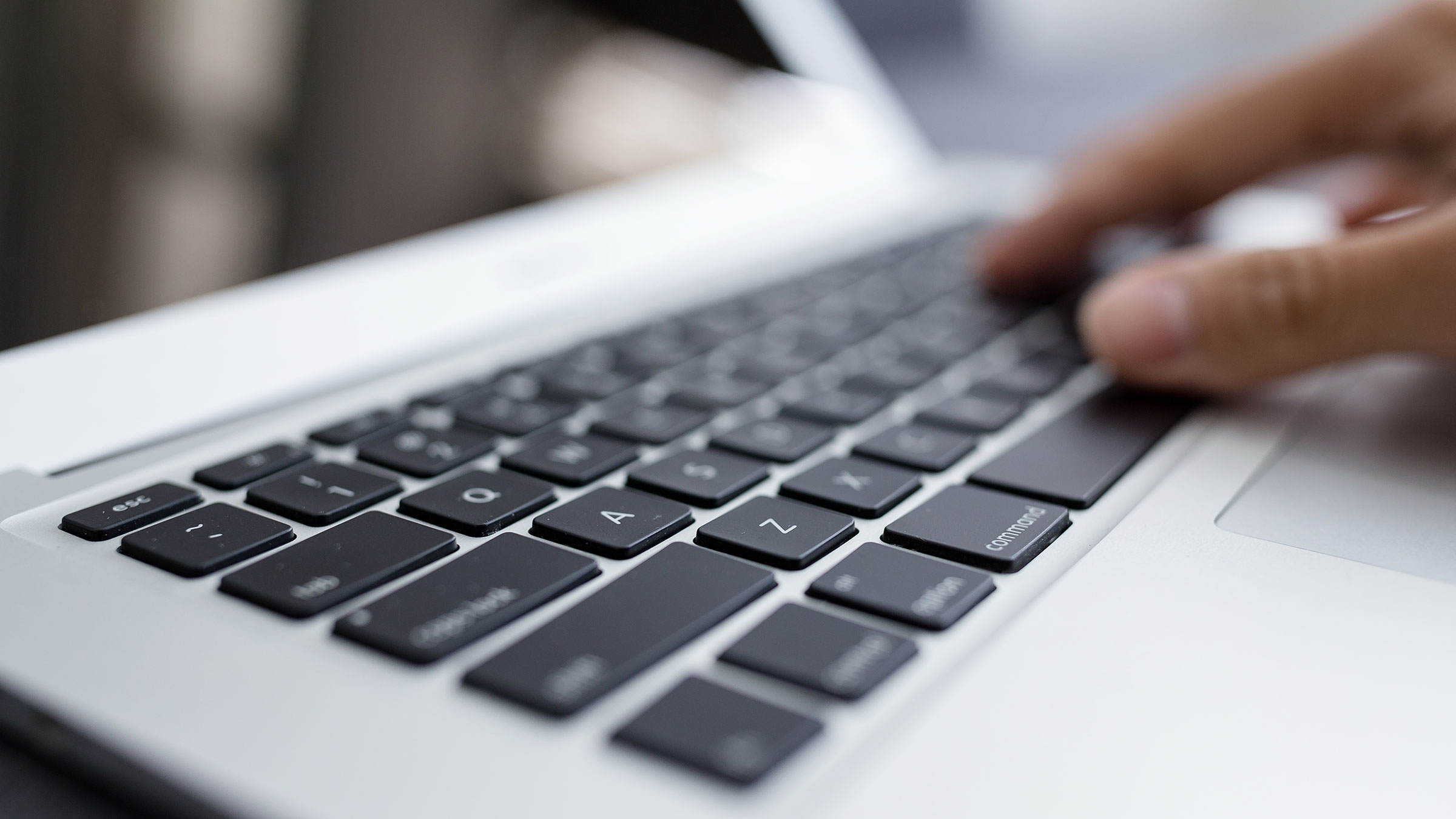 Closeup of man typing on laptop keyboard